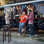 people at opening mobile fast food restaurant on wheels